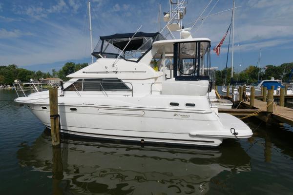 Slide: The Image of 1999 Cruisers Yachts 3750 Motoryacht docked in a marina under a clear sky. - 0