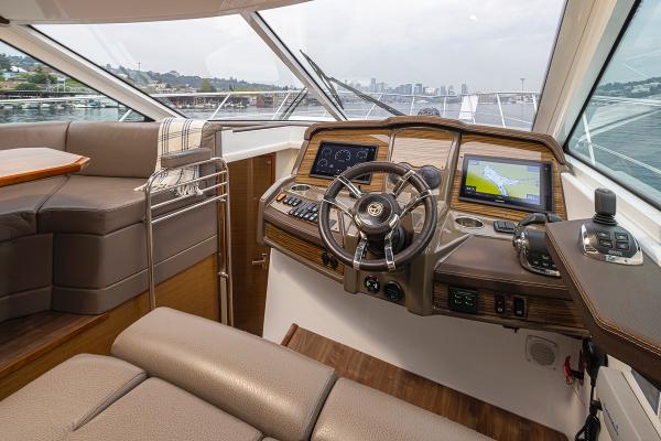Slide: The Image of 2018 Cruisers Yachts 45 Cantius helm with navigation screens and leather seating. - 13