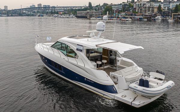 Slide: The Image of 2018 Cruisers Yachts 45 Cantius luxury motor yacht on a calm waterfront. - 2