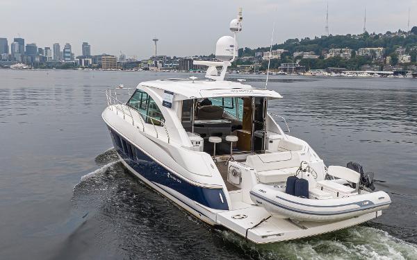 Slide: The Image of 2018 Cruisers Yachts 45 Cantius luxury yacht cruising on a calm waterway with city skyline. - 4