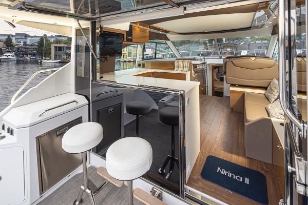 Slide: The Image of 2018 Cruisers Yachts 45 Cantius interior with bar stools, seating area, and waterfront view. - 6