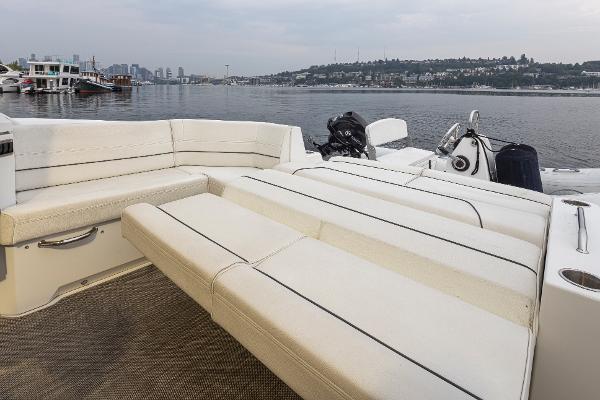 Slide: The Image of 2018 Cruisers Yachts 45 Cantius, spacious deck with white seating, docked by the waterfront. - 8