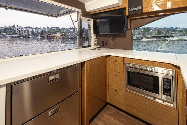 Slide: The Image of Modern kitchen area on 2018 Cruisers Yachts 45 Cantius with waterfront view. - 9
