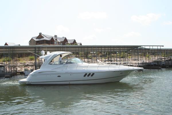 Slide: The Image of 2008 Cruisers Yachts 460 Express on water near dock and buildings. - 0