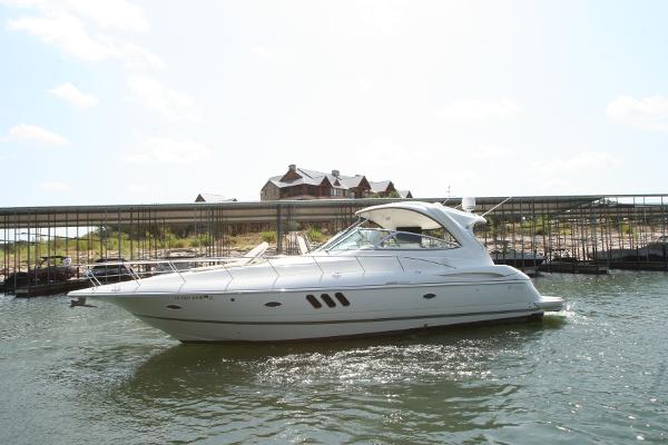 Slide: The Image of 2008 Cruisers Yachts 460 Express on water, docked near a marina with buildings in background. - 6