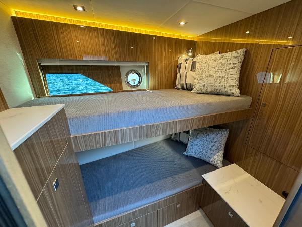 Slide: The Image of 2024 Cruisers Yachts 50 Cantius interior cabin with bunk beds and modern wood finish. - 20