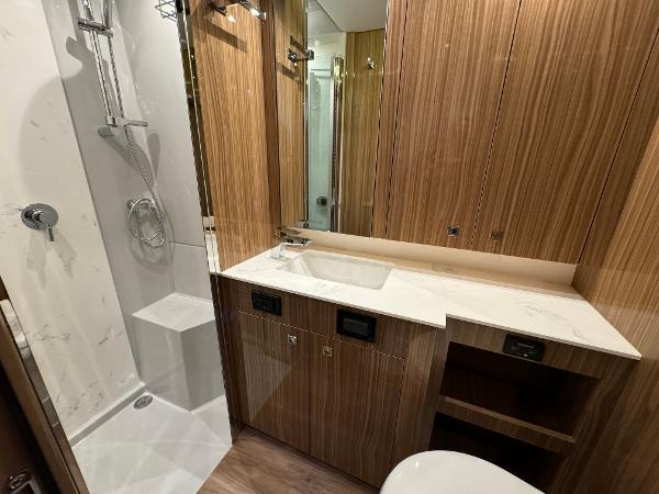 Slide: The Image of 2024 Cruisers Yachts 50 Cantius bathroom with modern shower and wooden cabinetry. - 21