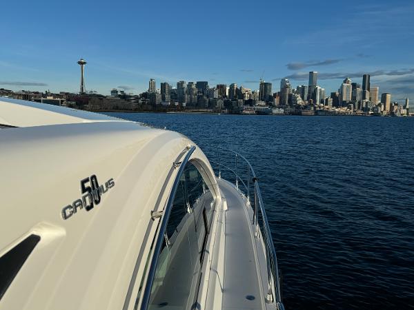 Slide: The Image of 2024 Cruisers Yachts 50 Cantius on water with city skyline in background. - 24
