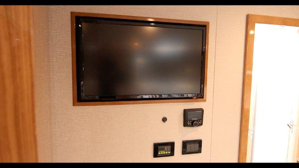 Slide: The Image of 2024 Cruisers Yachts 50 Cantius interior with wall-mounted TV and control panels. - 43