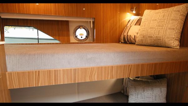 Slide: The Image of 2024 Cruisers Yachts 50 Cantius interior cabin with modern wooden finish and cozy bedding. - 49