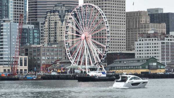 Slide: The Image of 2024 Cruisers Yachts 50 Cantius cruising near city waterfront with Ferris wheel. - 7
