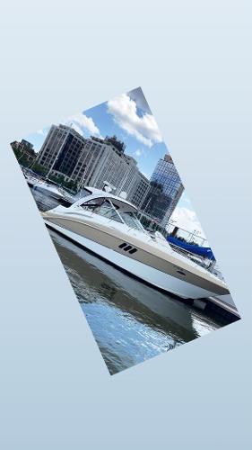 Slide: The Image of 2008 Cruisers Yachts Express docked in a marina with city skyline. - 11