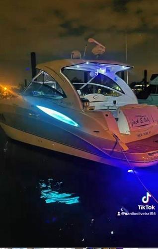 Slide: The Image of 2008 Cruisers Yachts Express with blue underwater lights docked at night. - 6