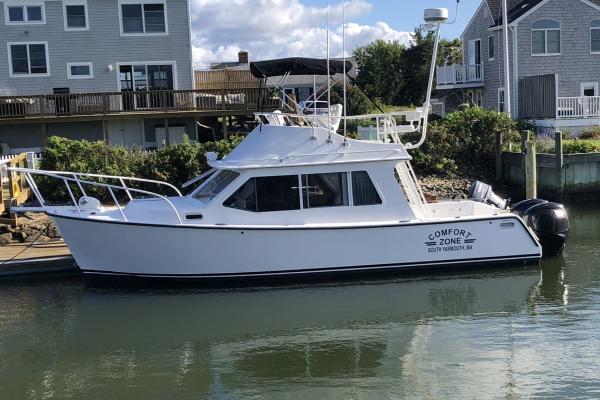 Slide: The Image of 2012 Crusader Boats outboard cruiser docked near waterfront homes. - 0