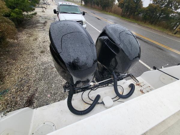 Slide: The Image of Two black outboard motors on a 2012 Crusader Boats cruiser, parked near a road. - 26