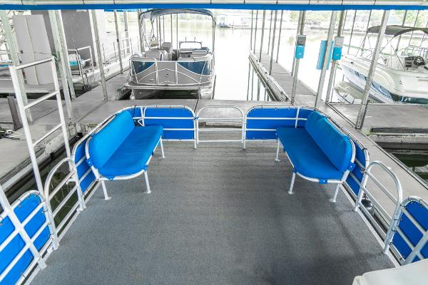 Slide: The Image of Custom Lake Wind 25 x 10 Pontoon, 2000 model, docked with blue seating. - 14