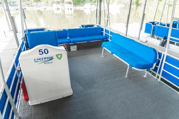 Slide: The Image of Custom 2000 Lake Wind 25 x 10 Pontoon with blue seating and carpeted deck. - 16