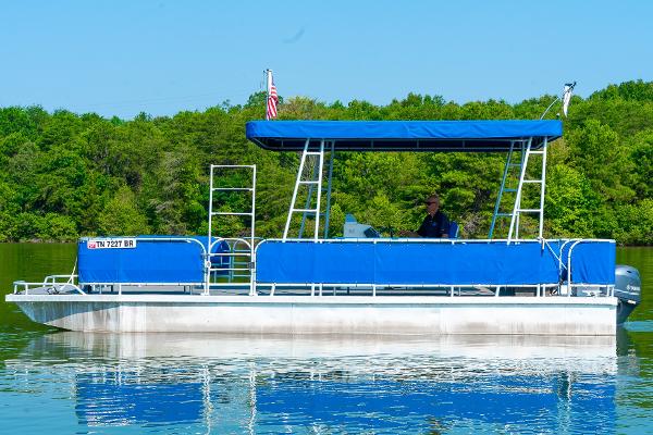 Slide: The Image of Custom 2000 Lake Wind 25 x 10 Pontoon boat on a calm lake. - 2