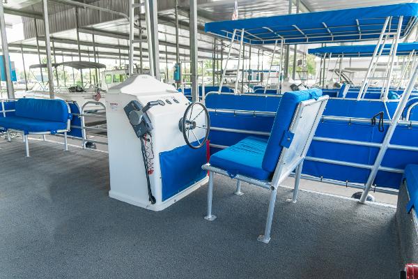 Slide: The Image of 2000 Custom Lake Wind 25 x 10 Pontoon boat interior with blue seating and steering console. - 21