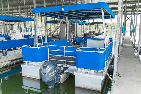Slide: The Image of Custom Lake Wind 25 x 10 Pontoon boat, 2000 model, docked with blue canopy and seating. - 6