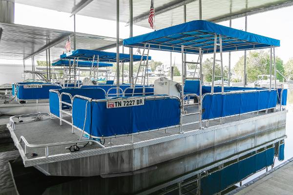 Slide: The Image of Custom 2000 Lake Wind 25 x 10 Pontoon boat with blue canopy docked in marina. - 7