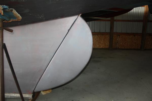 Slide: The Image of Close-up of the hull of a 1934 Custom Northern Michigan NM boat in a storage facility. - 13