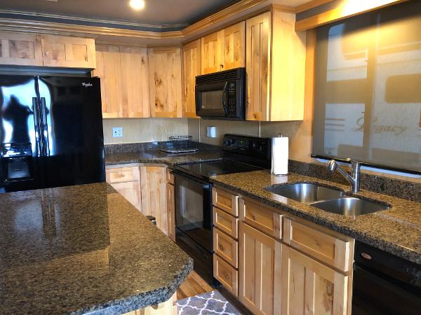 Slide: The Image of Modern kitchen with granite countertops, wooden cabinets, black appliances, and double sink. Custom model: The Entourage Shares #21,33 and 40 - 21