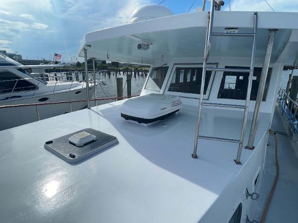 Slide: The Image of 1987 Custom Trawler Biloxi Lugger docked, showcasing sleek design and spacious deck area. - 10
