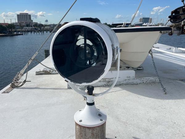 Slide: The Image of 1987 Custom Trawler Biloxi Lugger spotlight on deck, overlooking marina with clear skies. - 13