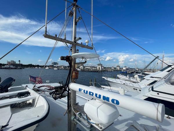 Slide: The Image of 1987 Custom Trawler Biloxi Lugger with Furuno radar, docked in a marina under a clear blue sky. - 14