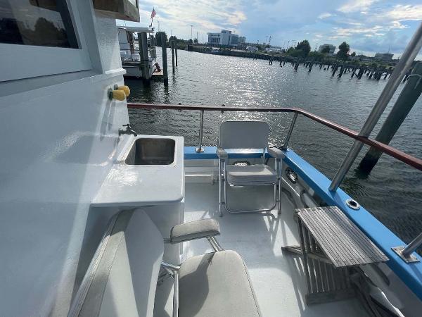 Slide: The Image of 1987 Custom Trawler Biloxi Lugger deck with seating, sink, and waterfront view. - 16
