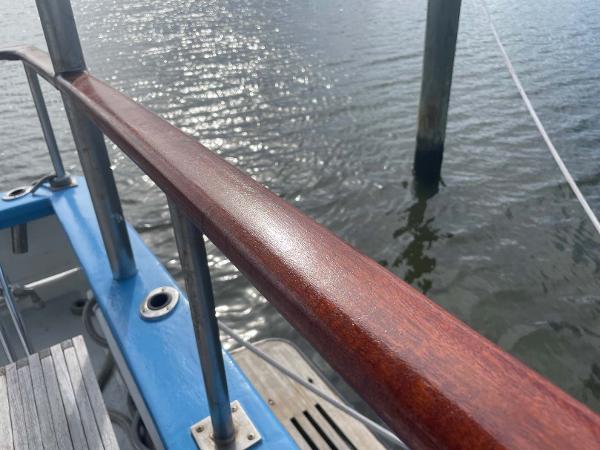 Slide: The Image of Polished wooden railing on 1987 Custom Trawler Biloxi Lugger, overlooking calm water. - 22