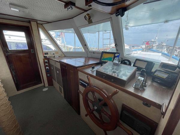 Slide: The Image of Pilothouse of 1987 Custom Trawler Biloxi Lugger with wooden wheel and navigation equipment. - 23