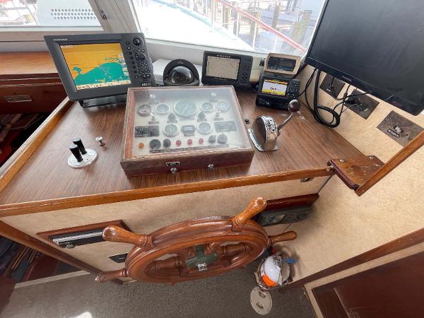 Slide: The Image of Control panel of 1987 Custom Trawler Biloxi Lugger with navigation equipment and wooden steering wheel. - 24