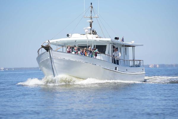 Slide: The Image of 1987 Custom Trawler Biloxi Lugger cruising on calm waters under clear blue skies. - 3