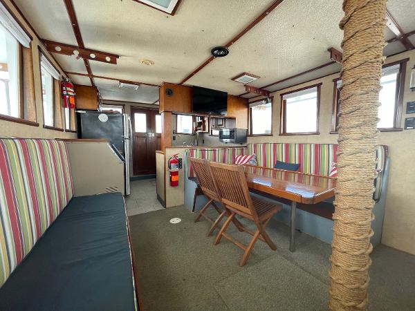 Slide: The Image of Interior of 1987 Custom Trawler Biloxi Lugger with striped seating, dining table, and kitchen area. - 30