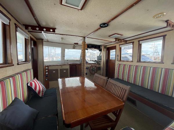 Slide: The Image of Interior of 1987 Custom Trawler Biloxi Lugger with striped seating and wooden dining table. - 32