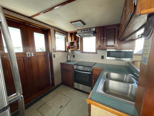 Slide: The Image of 1987 Custom Trawler Biloxi Lugger kitchen with wood cabinets, dual sink, and modern appliances. - 34