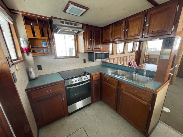 Slide: The Image of 1987 Custom Trawler Biloxi Lugger kitchen with wooden cabinets, stove, and double sink. - 35