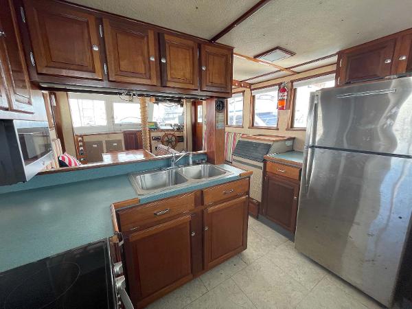 Slide: The Image of Kitchen interior of 1987 Custom Trawler Biloxi Lugger with wooden cabinets and stainless steel appliances. - 36