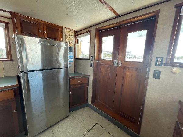 Slide: The Image of 1987 Custom Trawler Biloxi Lugger interior with stainless steel fridge and wooden cabinetry. - 37