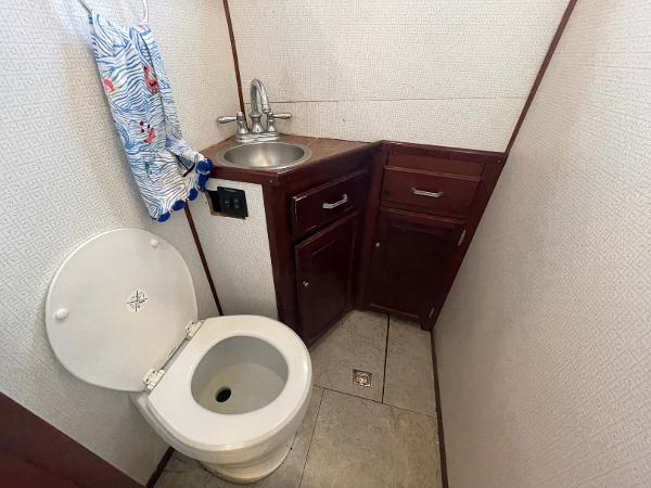 Slide: The Image of Compact bathroom in 1987 Custom Trawler Biloxi Lugger with sink, toilet, and storage cabinets. - 44