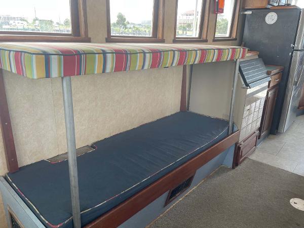 Slide: The Image of Interior of 1987 Custom Trawler Biloxi Lugger with striped seating and compact kitchen area. - 47