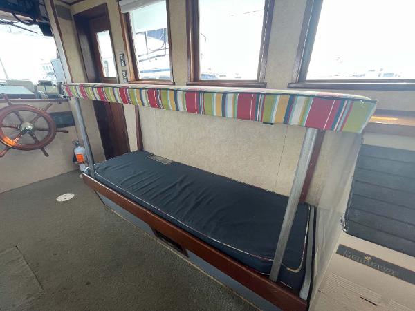 Slide: The Image of Interior of 1987 Custom Trawler Biloxi Lugger with striped seating and wooden steering wheel. - 48