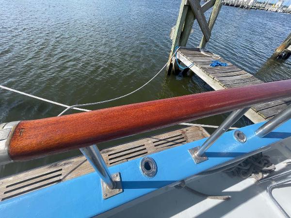 Slide: The Image of 1987 Custom Trawler Biloxi Lugger with wooden railing, docked by the water. - 7