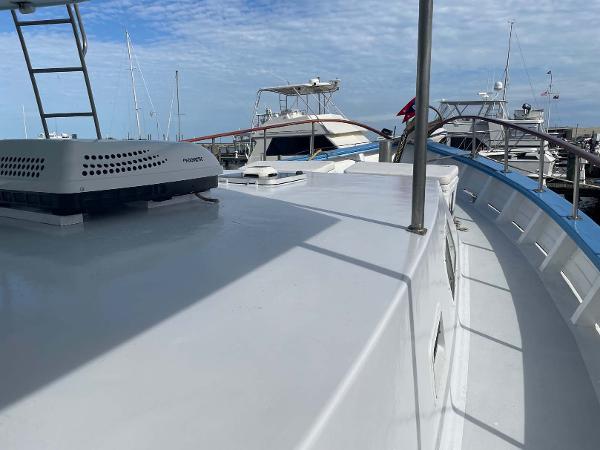 Slide: The Image of 1987 Custom Trawler Biloxi Lugger on deck, docked with other boats under a blue sky. - 9