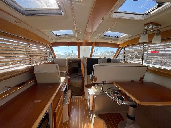 Slide: The Image of Interior of 2016 Cutwater 30 Sedan LE boat with wood finishes and ample natural light. - 16