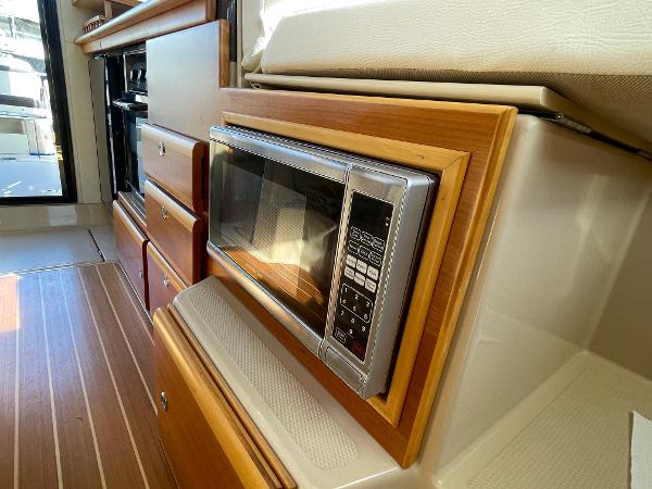 Slide: The Image of 2016 Cutwater 30 Sedan LE interior with microwave and wooden cabinetry. - 26