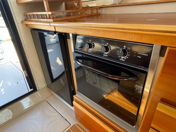 Slide: The Image of 2016 Cutwater 30 Sedan LE kitchen with wood cabinetry and built-in oven. - 30