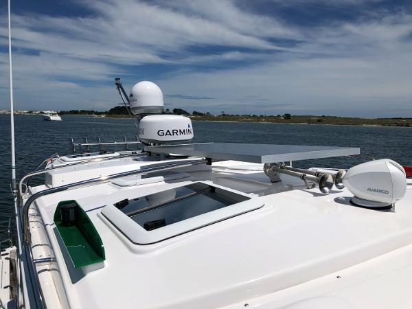 Slide: The Image of 2025 Cutwater C-32 Sedan boat with Garmin radar on calm water. - 16